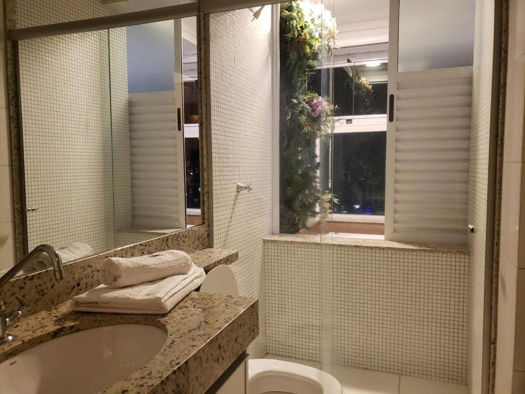y baño con lavabo, aseo y espejo. en Banho de Lua - Vaca Brava, en Goiânia