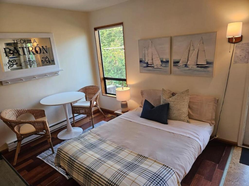 Schlafzimmer mit einem Bett, einem Tisch und Stühlen in der Unterkunft Pebbly Beach Suite in Snug Cove in Bowen Island