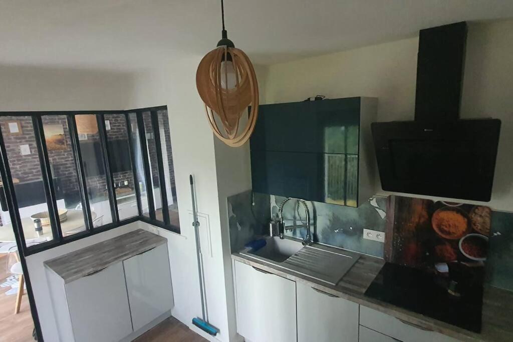 a kitchen with a refrigerator and a tv on the wall at Appartement T3 à Saint-Denis in Saint-Denis