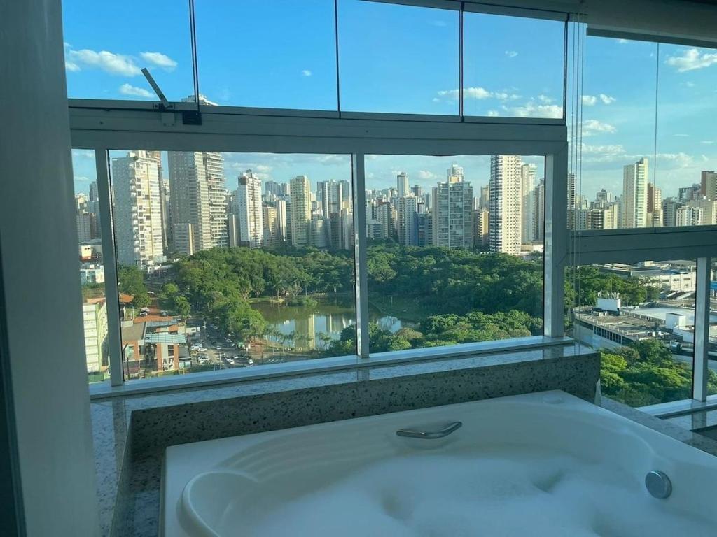 uma banheira na casa de banho com vista para a cidade em Encantare - Easy Life - Vaca em Goiânia