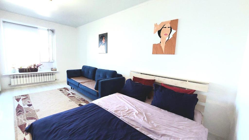 een slaapkamer met een bed en een bank bij Аэропорт 10 минут in Astana