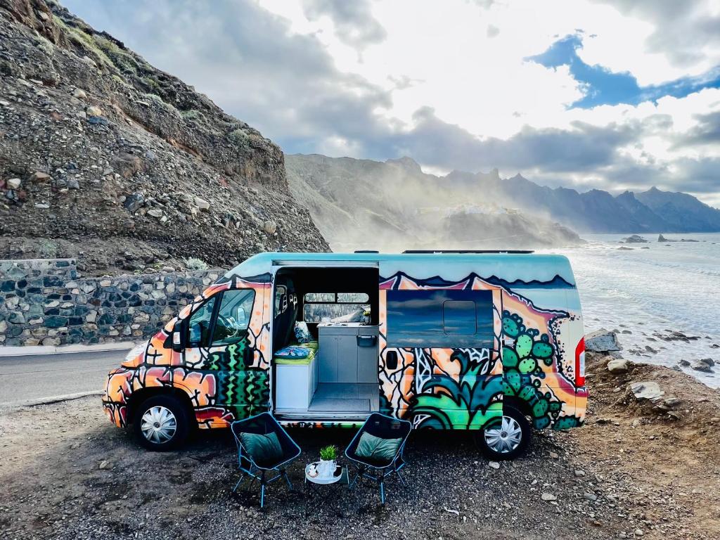 a van parked on the side of a beach with chairs at On Road- feel freedom with campervan! in El Guincho