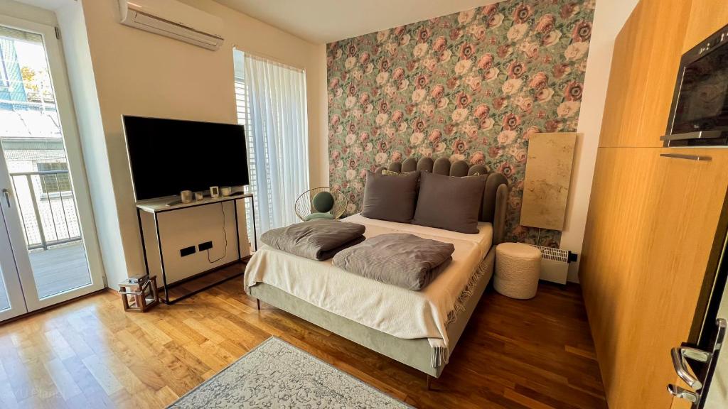 een slaapkamer met een bed en een tv in een kamer bij Triangle City Center Apartment in Wenen