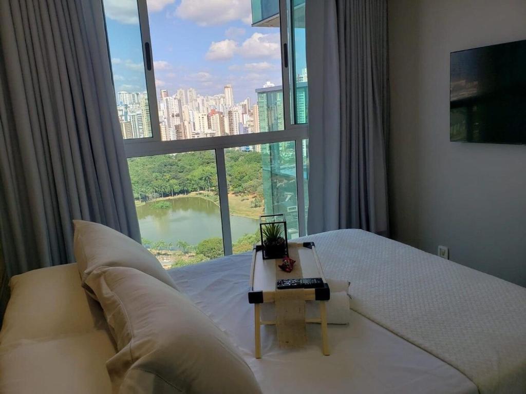 a bedroom with a white bed and a large window at 01 Qt.| 2 Hosp. | Linda Vista | Goiânia Shopping in Goiânia