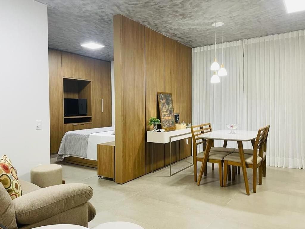 a bedroom with a bed and a table and chairs at Vida Urbana - Zen - Setor Oeste in Goiânia