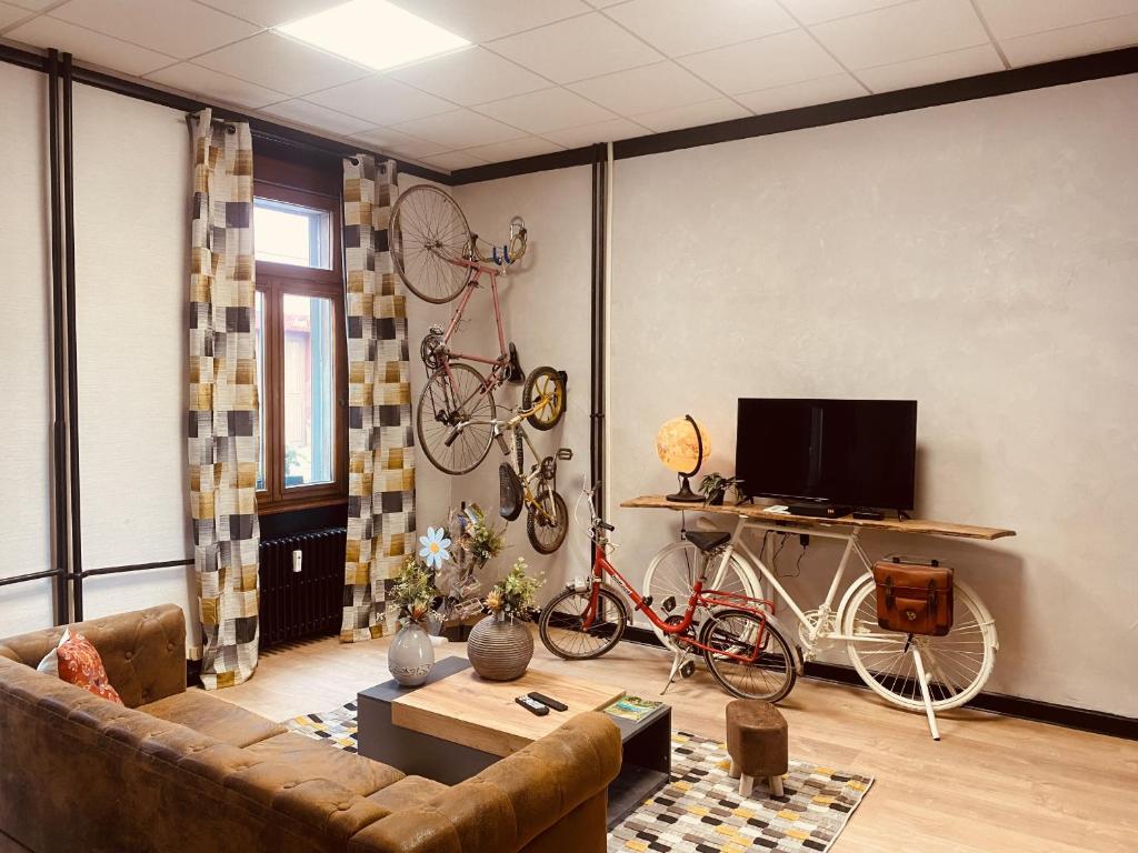 - un salon avec un canapé et 2 vélos sur le mur dans l'établissement LA MARIEFACTURE - Comme à la Bicyclette, à La Petite-Pierre