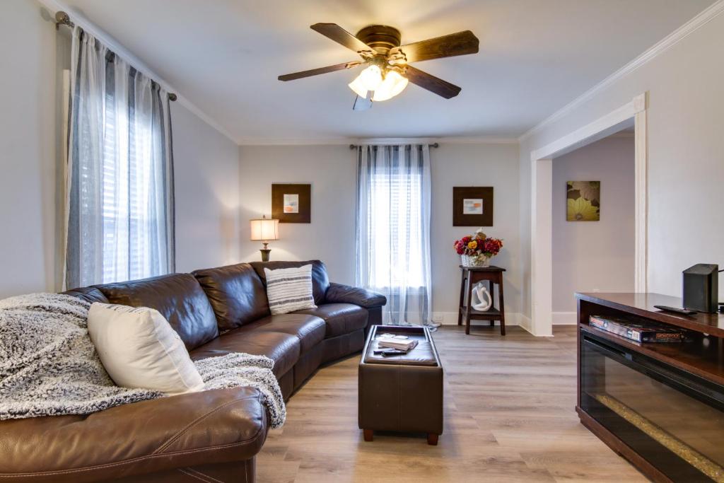a living room with a brown leather couch and a ceiling fan at Charming Salisbury Getaway with Grill and Fire Pit! in Salisbury