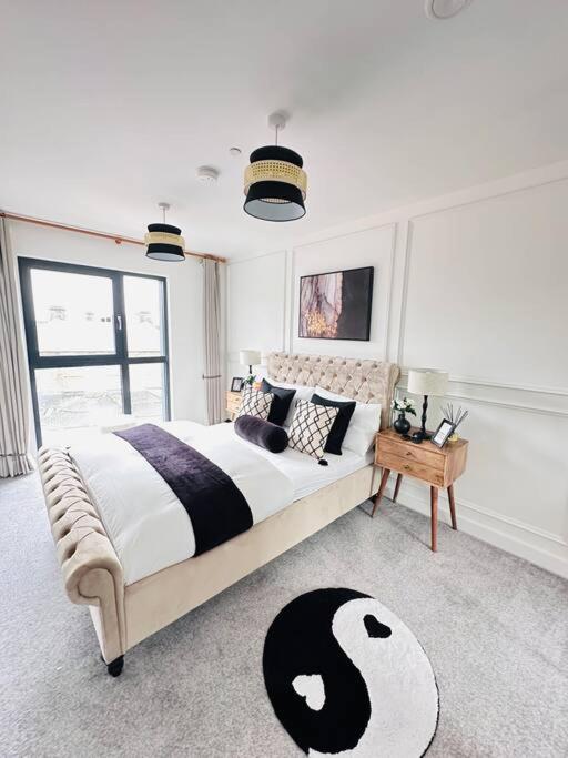 a bedroom with a bed with a black and white comforter at Central Derby Urban 2 Bedroom Flat - An Oasis of Elegance! Free Parking and Wifi suitable for families and professionals in Derby