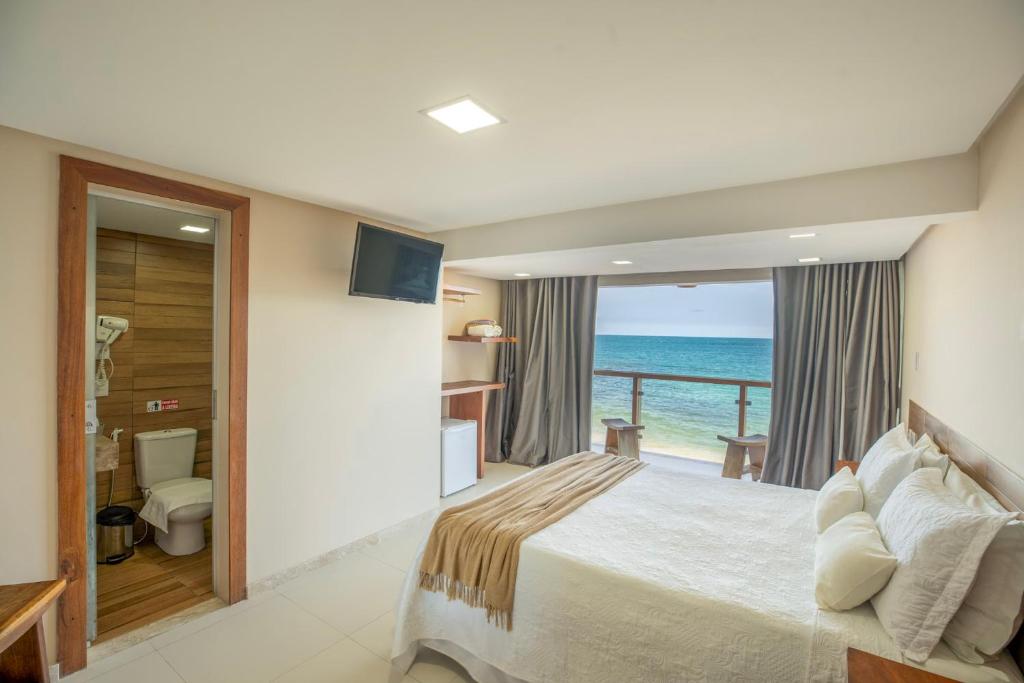 1 dormitorio con cama y vistas al océano en Pousada Manhã Dourada, en Morro de São Paulo