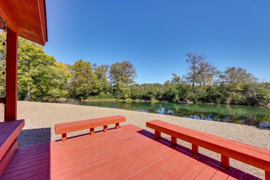 dos bancos sentados en una terraza de madera junto a un río en Riverfront Arkansas Abode - Furnished Deck and Grill, en Mount Ida