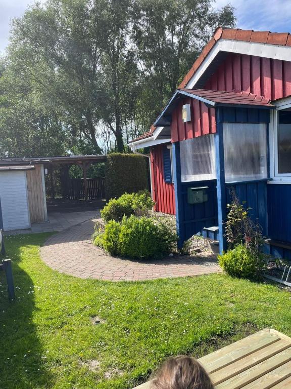 a person sitting on a bench in front of a house at Suedseeurlaub2 - Ferienhaus in Otterndorf in Otterndorf
