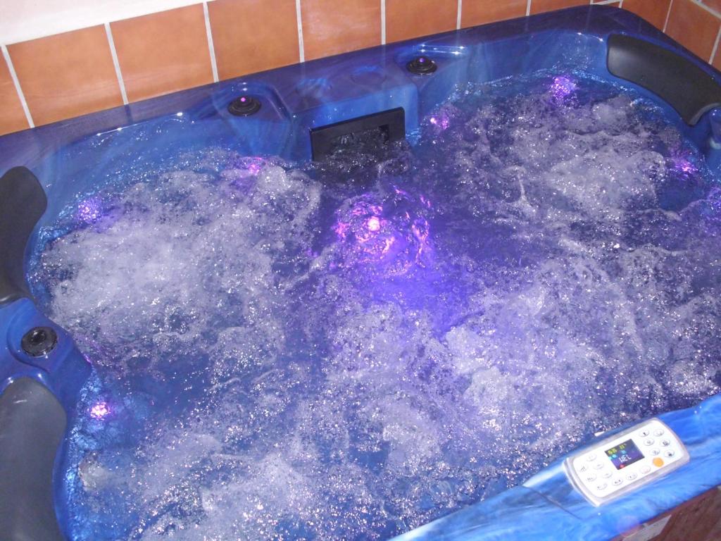 a large pool of water in a blue tub at Casa Rural con Jacuzzi Taberna del Tio Pedro in Cabañas de Polendos