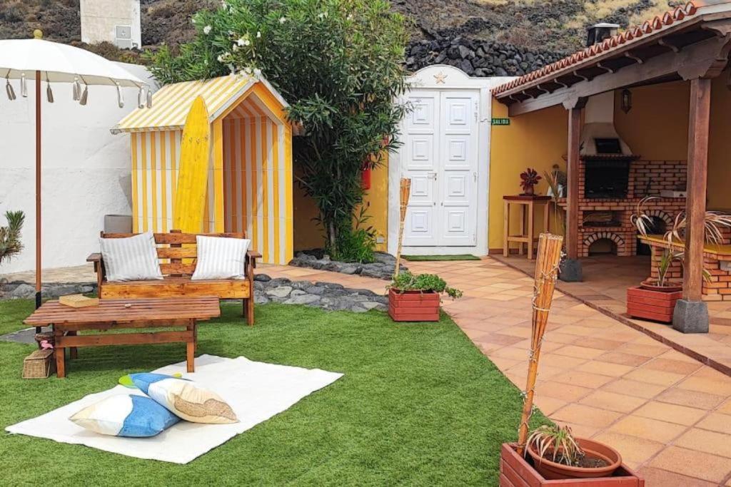 Mazo的住宿－Viento de Sal，一个带长凳的院子和一个带冲浪板的房子