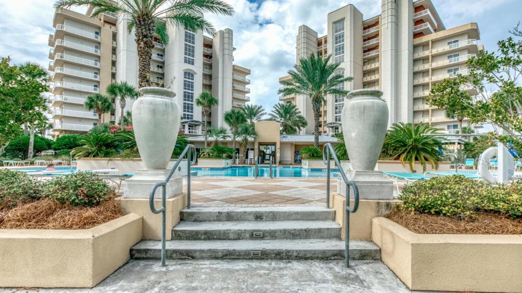 a stairway leading to a swimming pool with tall buildings at Harbor Landing 701B - 3BR Luxury condo with Gulf and Destin Harbor Views in Destin