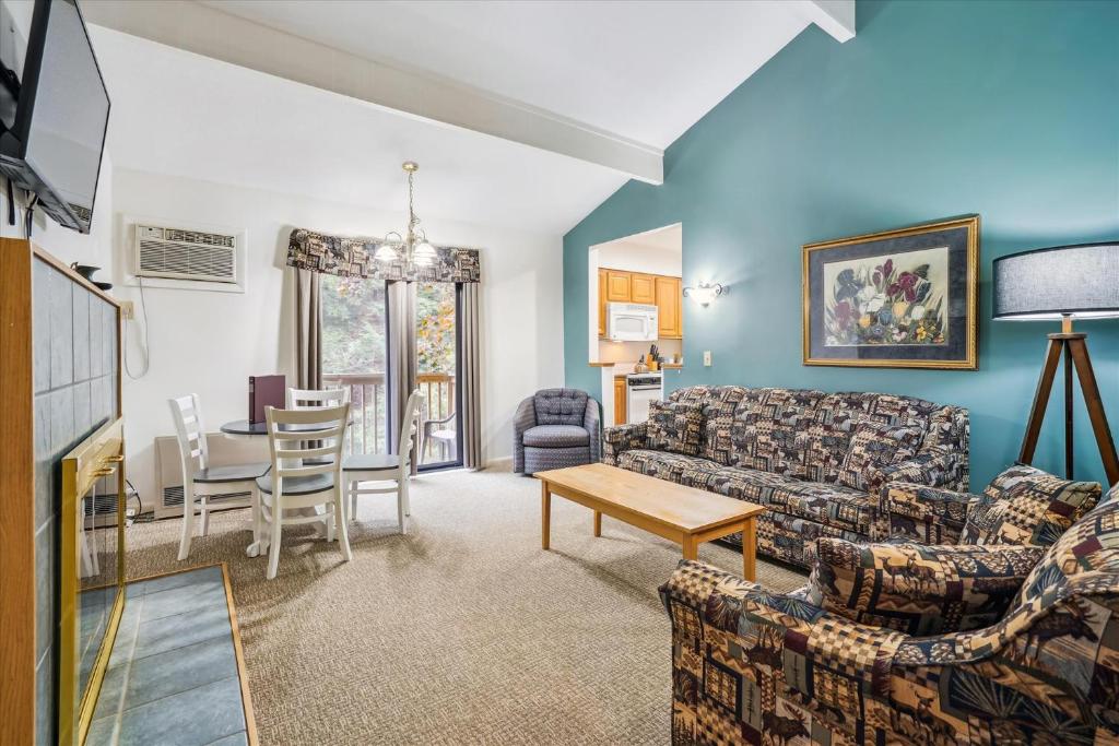 a living room with a couch and a table at Cedarbrook Queen Suite 109 in Killington