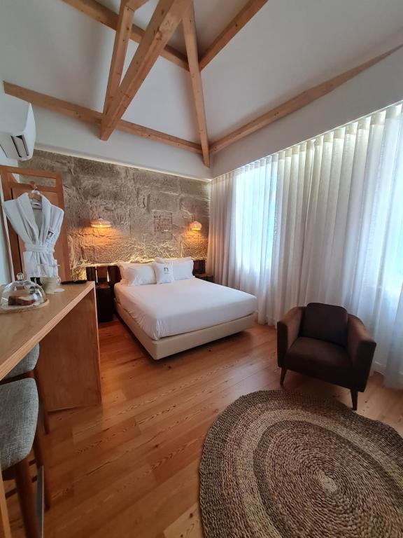 1 dormitorio con 1 cama y 1 silla en una habitación en Porta Nobre - Exclusive Living Hotel, en Oporto