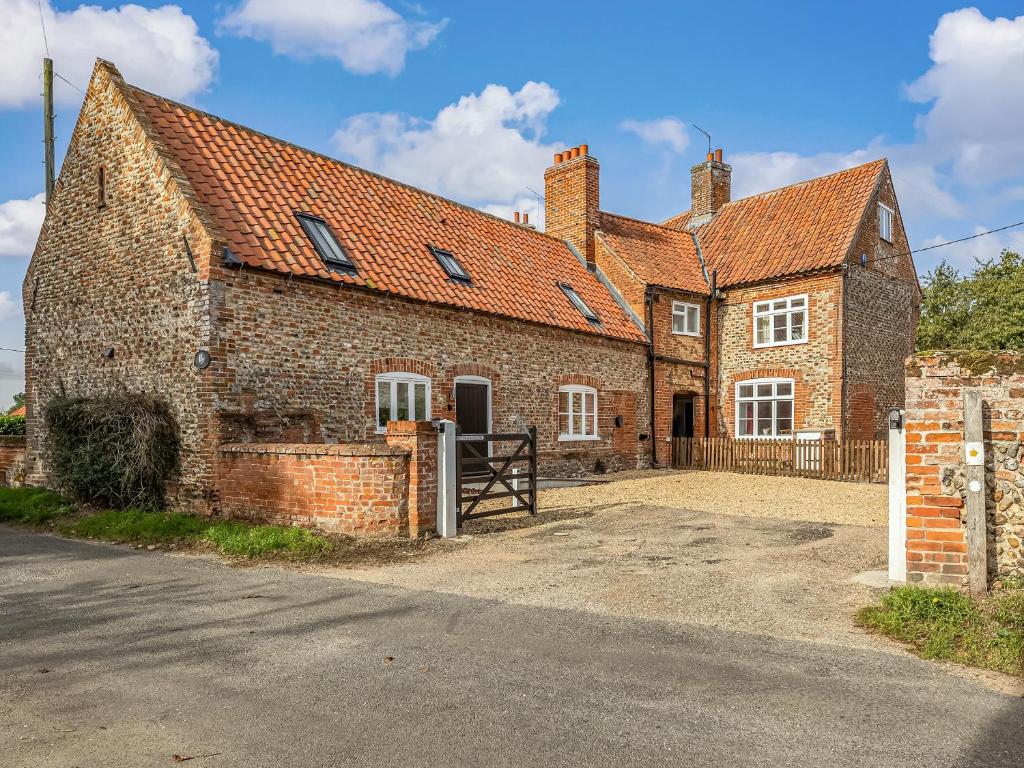 an old brick house with a gate in front of it at The Old Laundry in Great Snoring