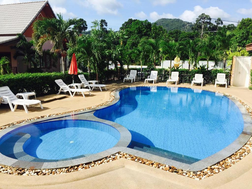 einen Pool mit Liegestühlen und Stühlen um ihn herum in der Unterkunft Natural Samui Hotel in Bophut 