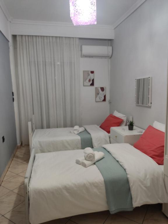 a bedroom with three beds with towels on them at Rafaela's Apartment in Kavala