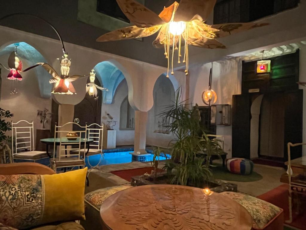 a living room with a table and a ceiling at Riad Al Ibtikar in Marrakesh