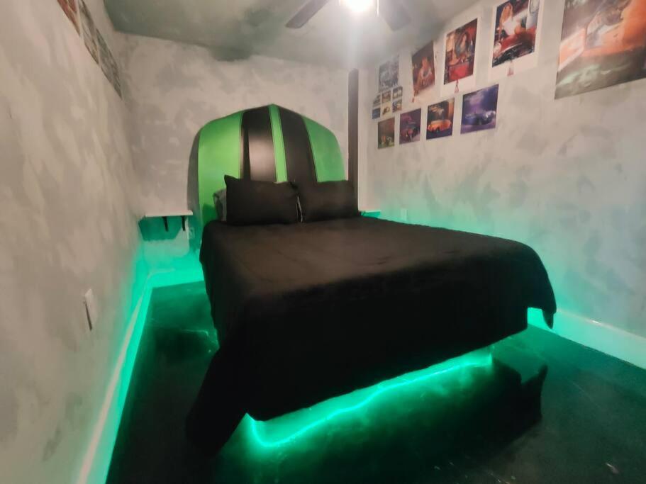 um quarto com uma cama com luzes verdes no chão em Downtown Chop Shop house, HUGE garage pets allowed em Fort Smith