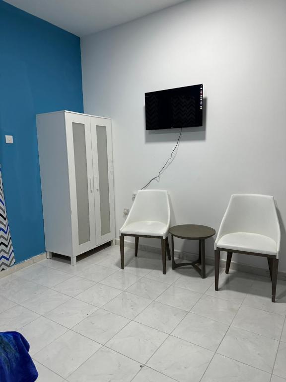杜拜的住宿－Studio Room，一间设有两把椅子和一台墙上电视的等候室