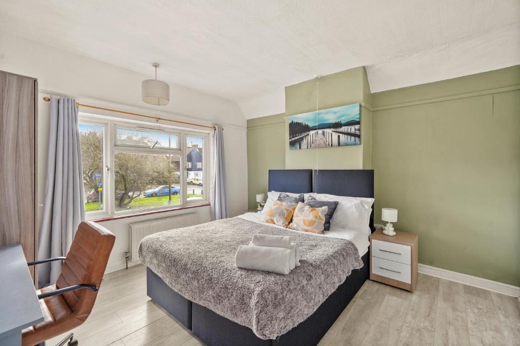 sypialnia z dużym łóżkiem i oknem w obiekcie BridgeCity 3 bed House in Maidstone Town Centre w mieście Kent