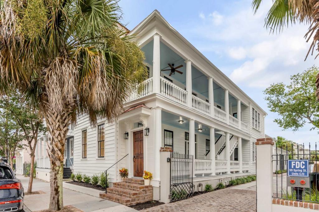 a white house with a porch and a tree at The Palmetto House B- Walk To King Street in Charleston