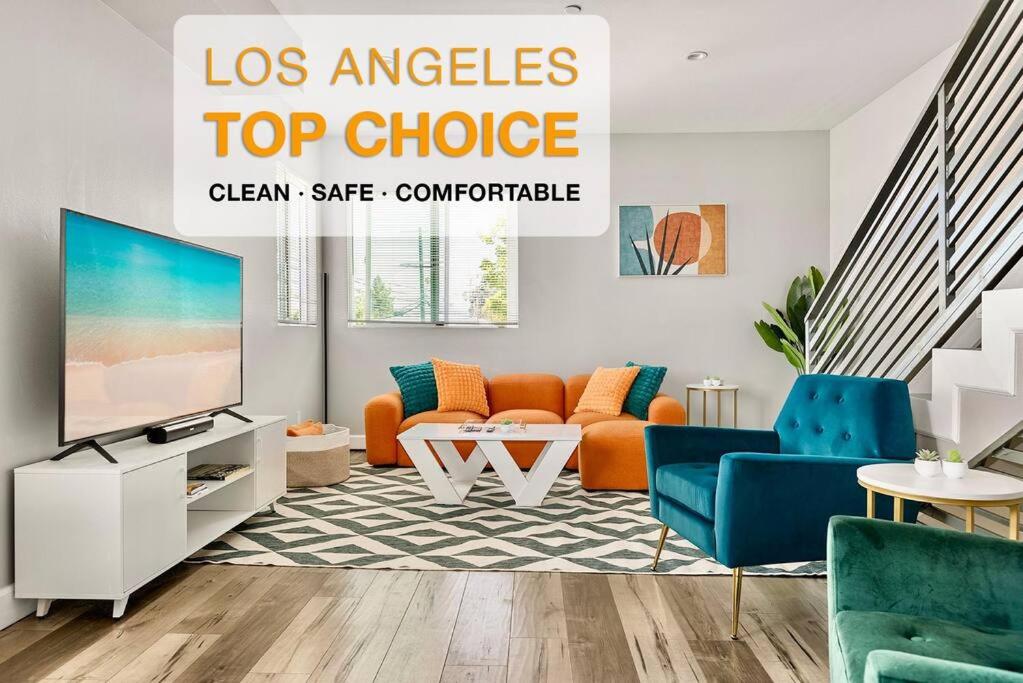 a living room with orange furniture and a flat screen tv at Fun Mid-City New Home Sleeps 10 Near USC/DTLA/Expo in Los Angeles