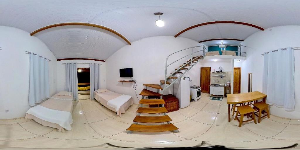 une grande chambre avec un escalier en colimaçon. dans l'établissement Flats Maraú - Taipu de Fora Bahia, à Marau
