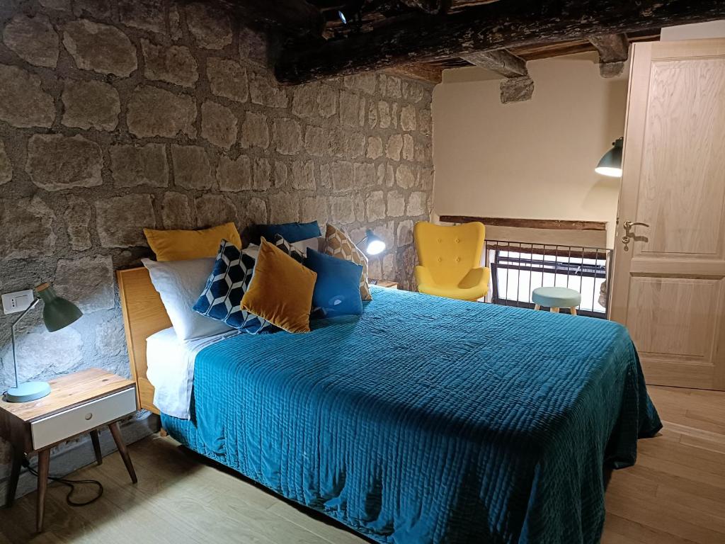 a bedroom with a bed and a stone wall at Il Paradosso Suite in Viterbo