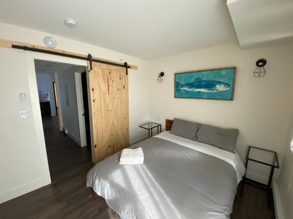 um quarto com uma cama branca e uma porta de madeira em Calming 1bedroom Units With Balcony And City View em Edmonton