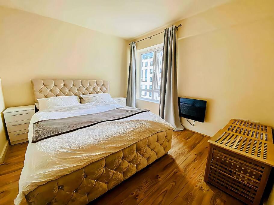 a bedroom with a large bed and a window at Secure 2BR 1BA Apartment for 6 in Colindale