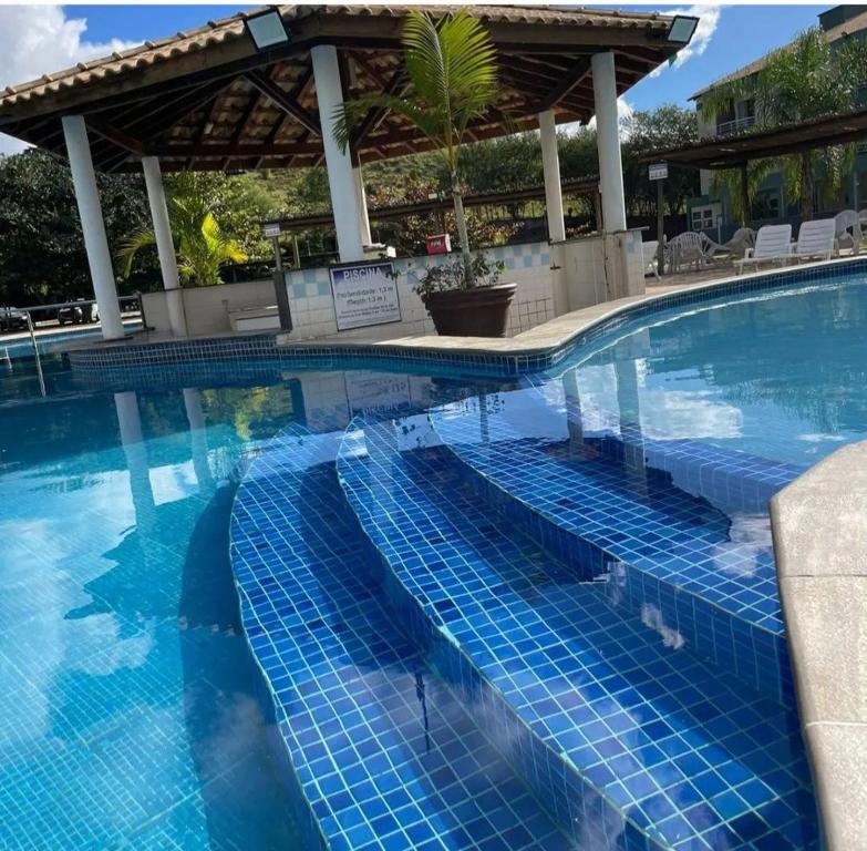 uma piscina com azulejos azuis num resort em Flat Aldeia das Águas em Barra do Piraí