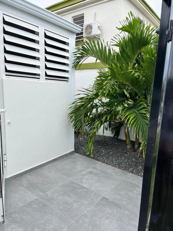 a white garage door with shutters and plants at Jm.HouseSxm in Koolbaai