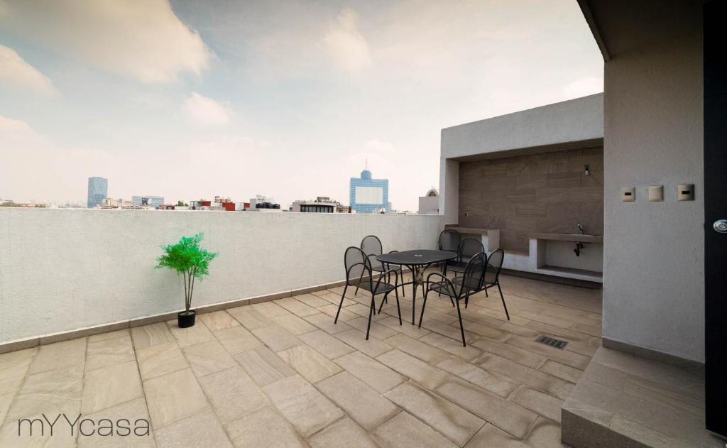 a patio with a table and chairs on a balcony at Wisconsin 68 PH1 · Brand New PH with Private Rooftop @ WTC in Mexico City