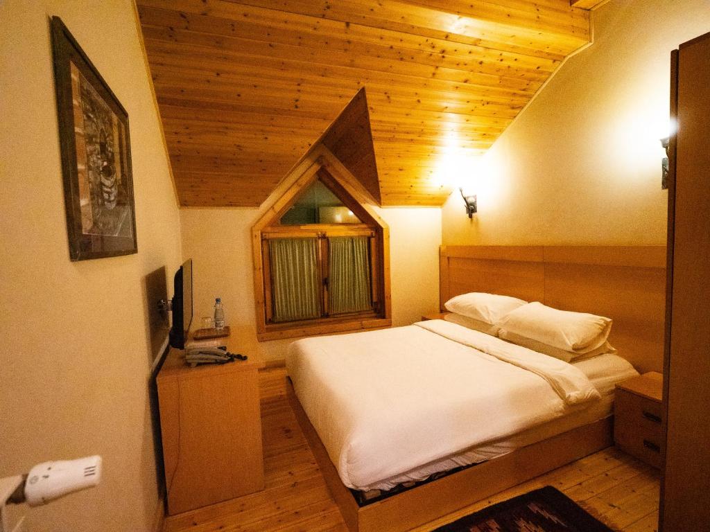 una camera con letto e finestra di Natyral Razma Resort a Razëm