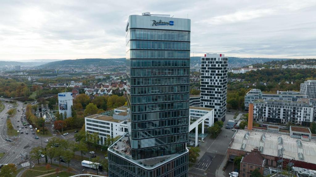 斯圖加特的住宿－Radisson Blu Hotel at Porsche Design Tower Stuttgart，一座高大的玻璃建筑,在城市里,有建筑