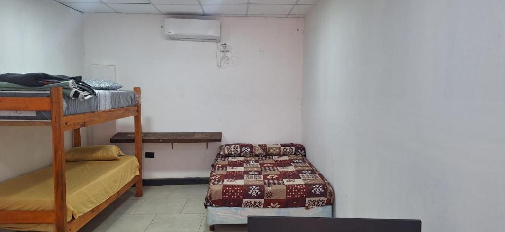 Pokój z łóżkiem i stołem oraz łóżkiem gmaxwell gmaxwell w obiekcie Hostel Mariscal w mieście Corrientes