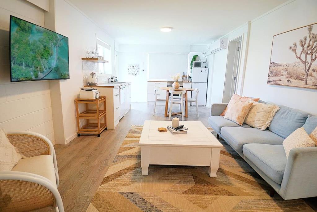 sala de estar con sofá y mesa de centro en Spacious, bright & central home with all amenities, en Auckland