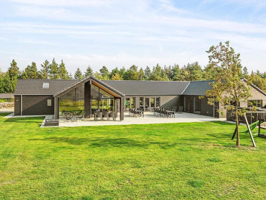 a house with glass doors and a yard at Luxury Retreat with Pool - By Traum Ferienwohnungen in Nørre Nebel