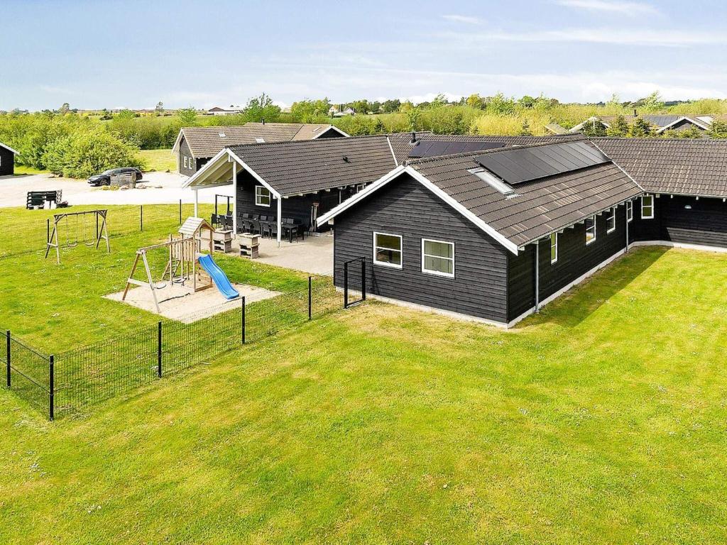 a black house with a playground in a yard at Luxury Retreat by Beach - By Traum Ferienwohnungen in Marielyst