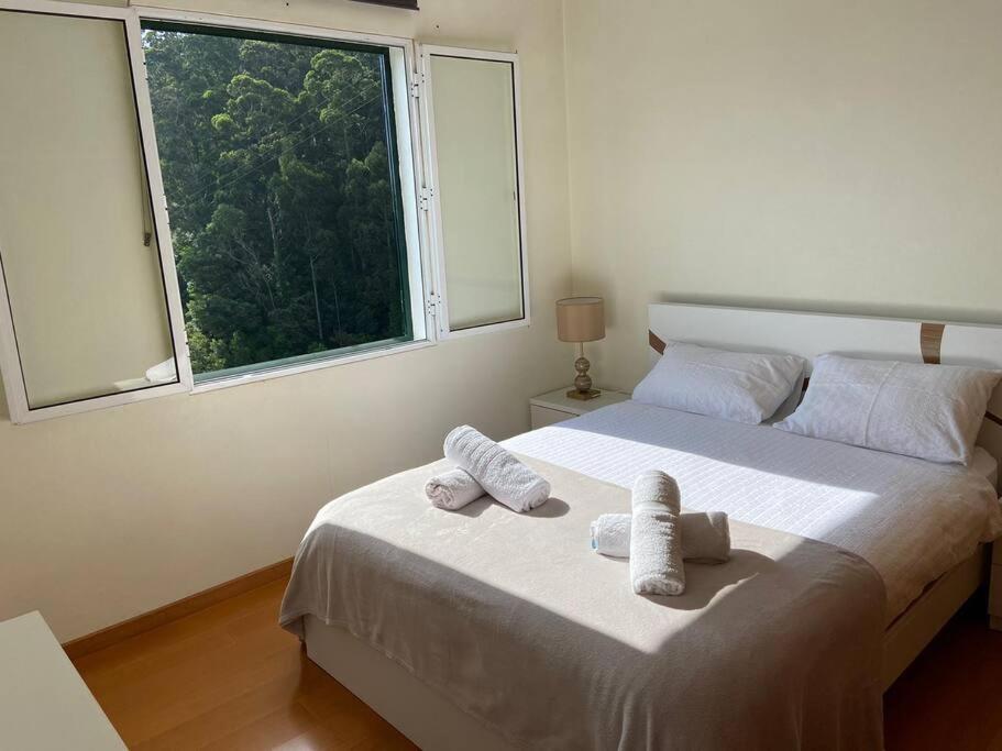 a bedroom with a large bed with towels on it at The Hideaway Retreat in Santo da Serra
