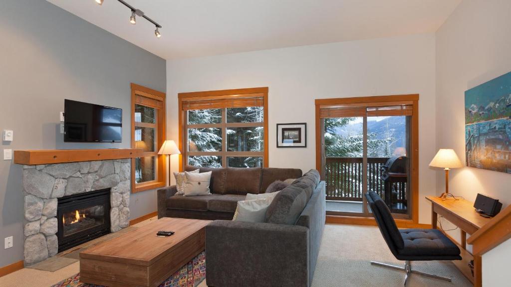 a living room with a couch and a fireplace at Mountain Star 1 - Luxury Townhome, Mountain Views, Hot Tub & BBQ - Whistler Platinum in Whistler