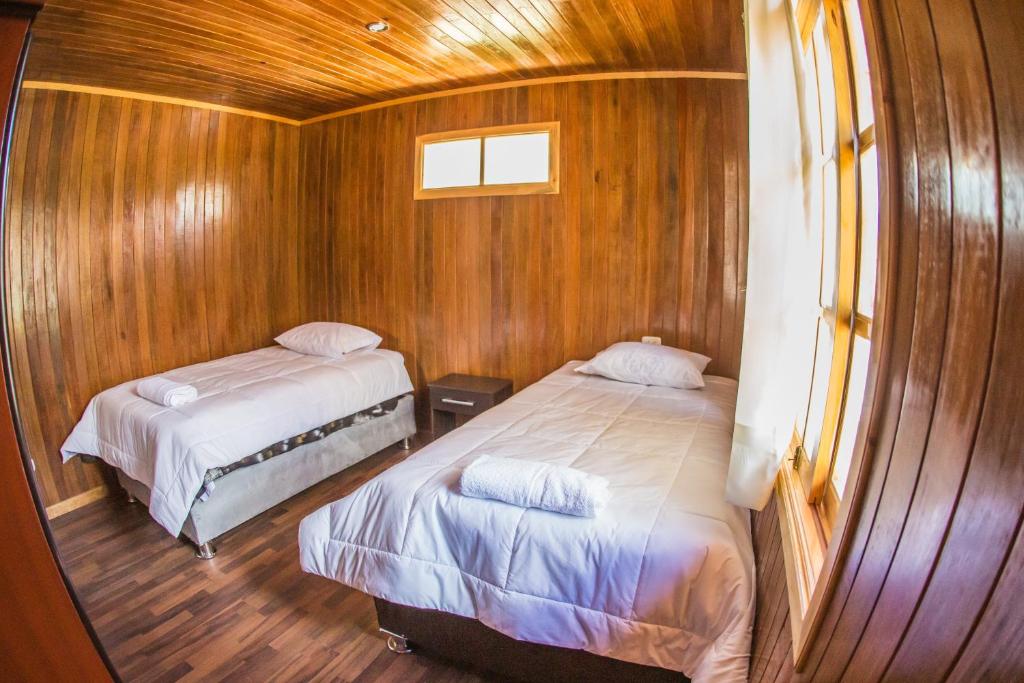 1 dormitorio con 2 camas en un barco de madera en Edelweishaus, en Chontabamba