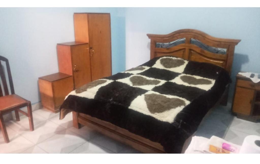 1 dormitorio con 1 cama con manta blanca y negra en Como en casa, en Sucre