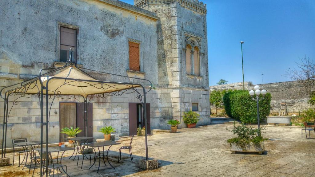 an outdoor patio with a table and chairs in front of a building at Villa Papaleo B&B in Bagnolo del Salento
