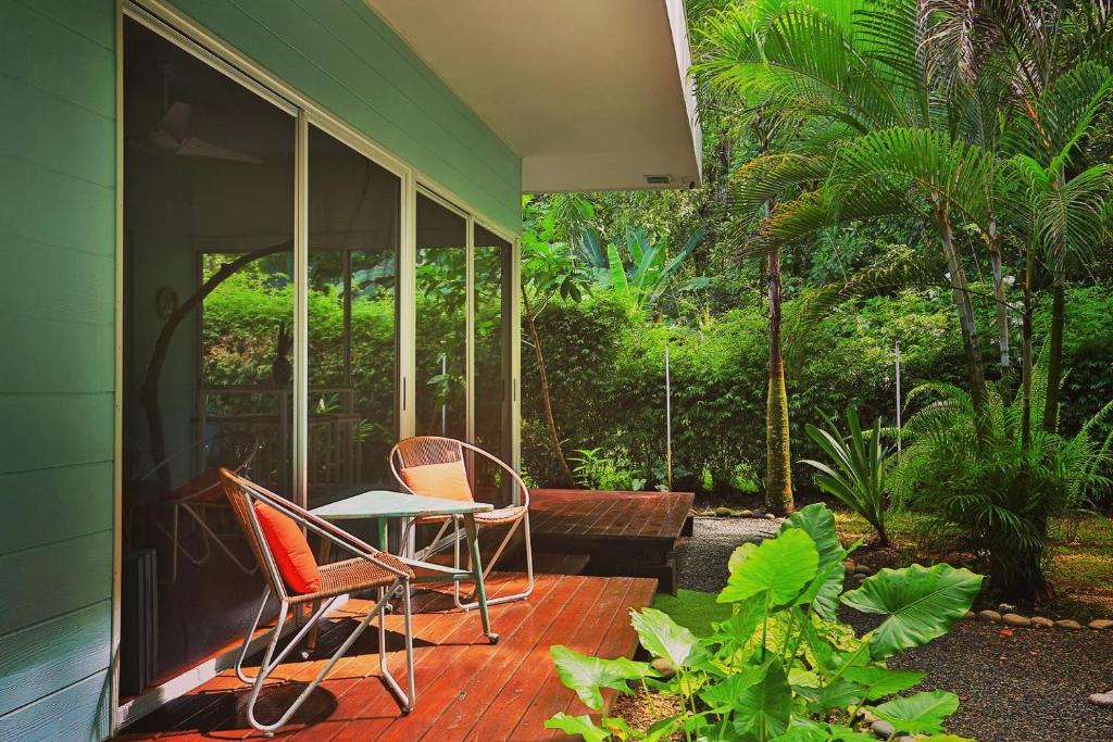 a patio with two chairs and a table on a house at Ojochal Gardens in Ojochal