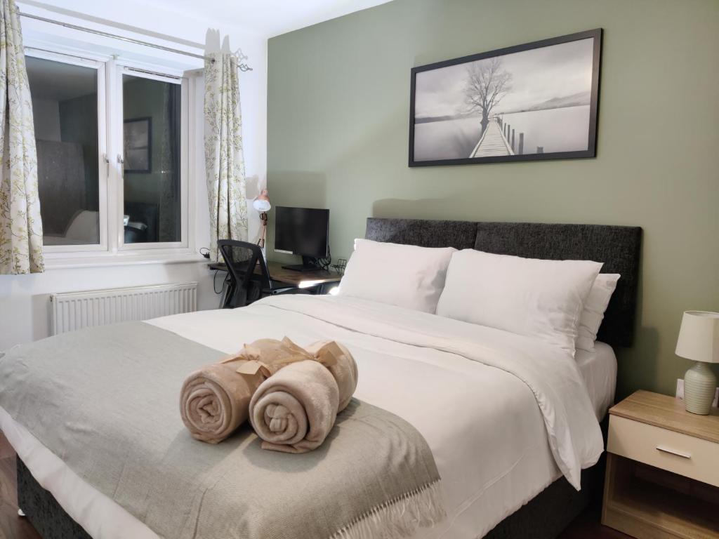 a bedroom with a bed with two towels on it at Elegant, Spacious 2bed in Crystal Palace, London in Crystal Palace