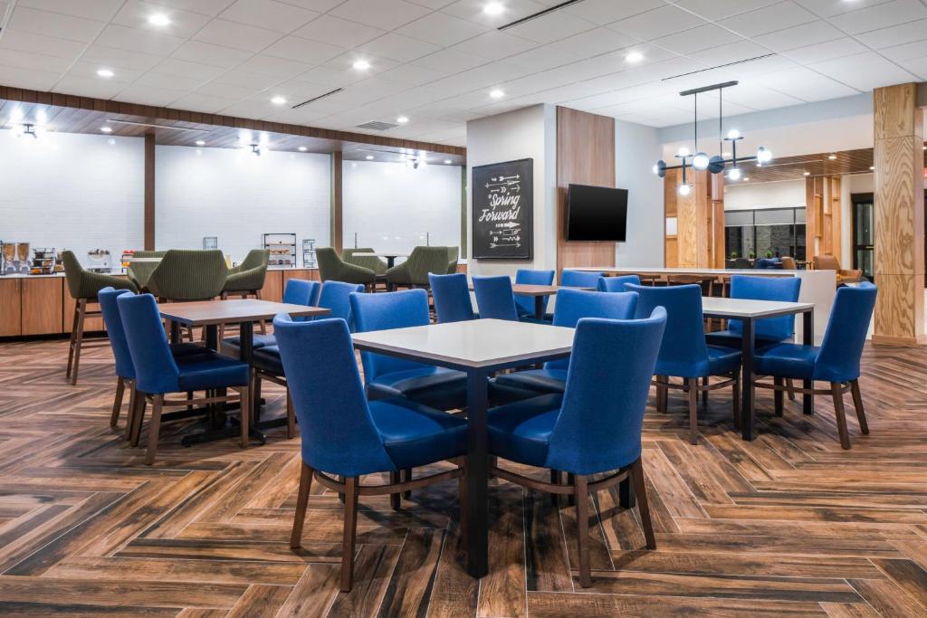 a restaurant with blue chairs and tables and a counter at Fairfield by Marriott Inn & Suites Corinth South Denton Area in Corinth